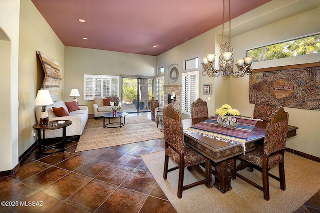 dining area featuring a notable chandelier, recessed lighting, dark tile patterned floors, a fireplace, and baseboards