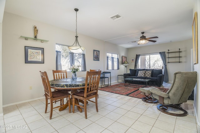 dining space featuring light tile patterned floors, visible vents, baseboards, and a ceiling fan