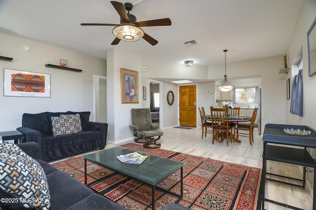 living room with ceiling fan, light tile patterned flooring, visible vents, and baseboards