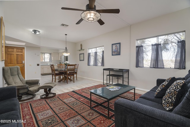 living area featuring a wealth of natural light, light tile patterned flooring, visible vents, and baseboards