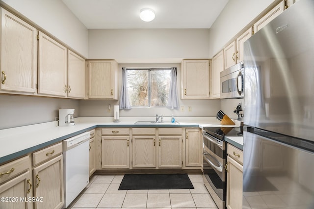 kitchen with appliances with stainless steel finishes, light brown cabinets, a sink, and light tile patterned floors