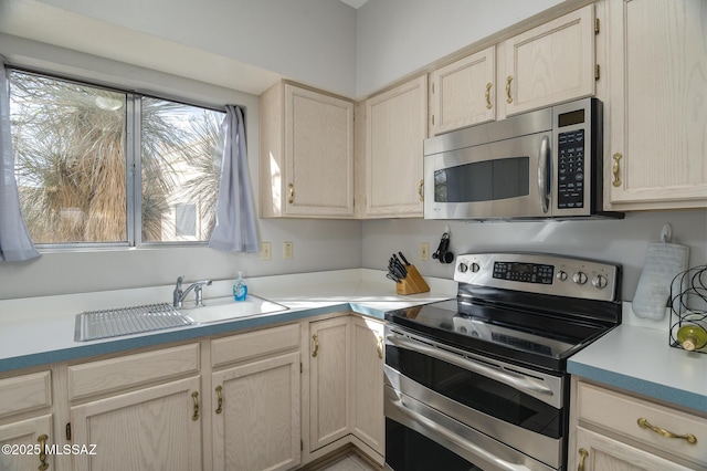 kitchen featuring stainless steel appliances, light countertops, and a sink