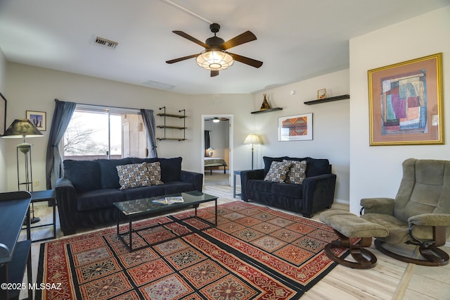 living area featuring ceiling fan and visible vents