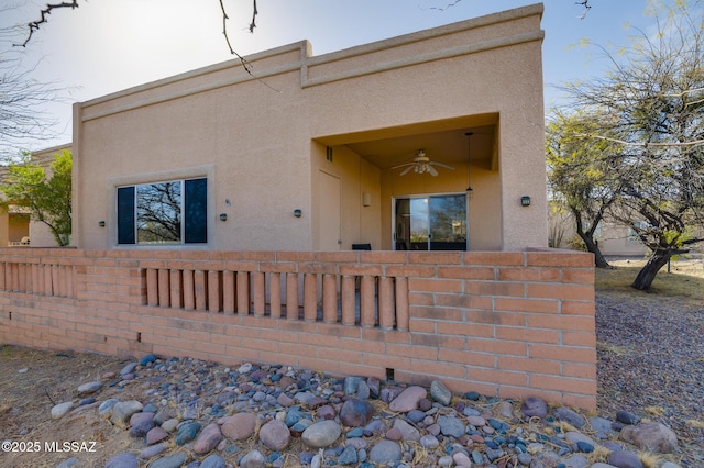 view of front of house featuring a fenced front yard, a ceiling fan, and stucco siding