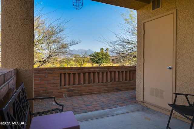 view of patio featuring visible vents, fence, and a mountain view