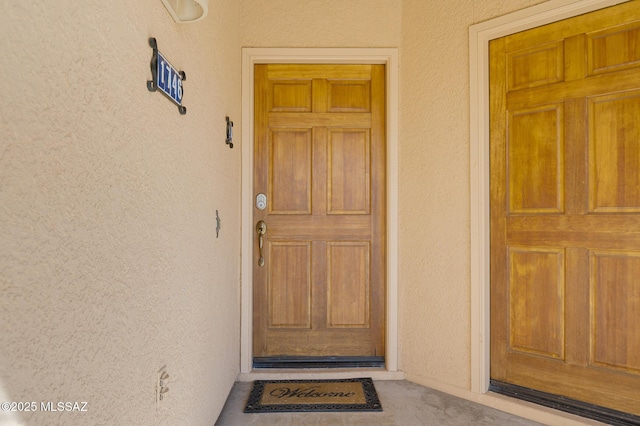 doorway to property featuring stucco siding