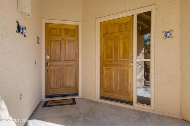 doorway to property featuring stucco siding