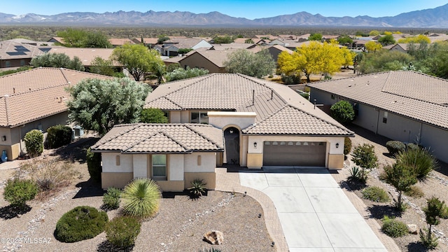 view of front of property featuring a residential view, an attached garage, stucco siding, concrete driveway, and a tiled roof