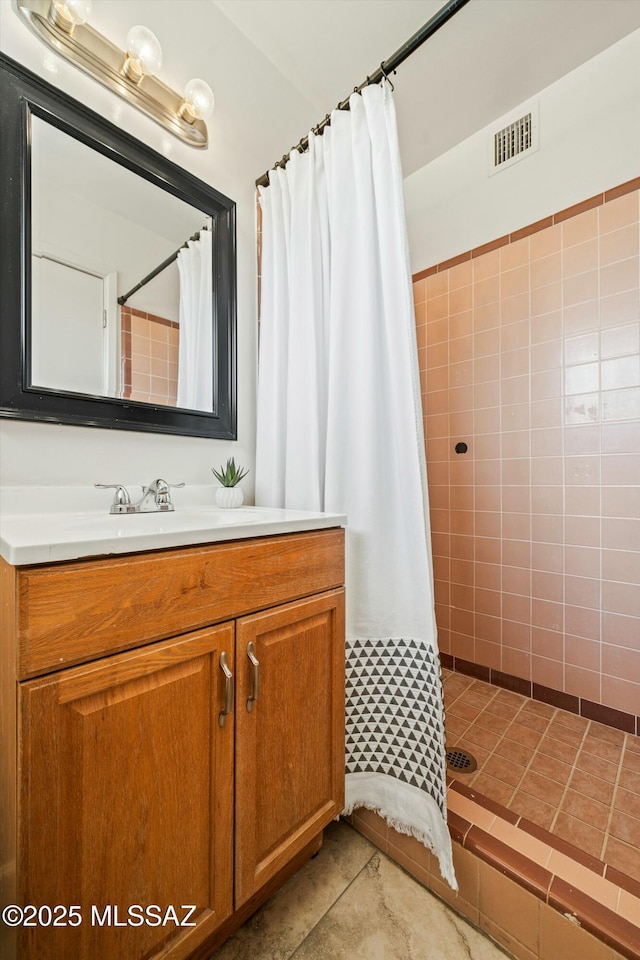 bathroom with a stall shower, tile patterned flooring, vanity, and visible vents