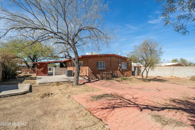 rear view of house with fence private yard, a patio, cooling unit, and brick siding