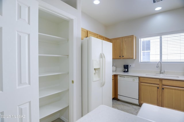 kitchen featuring recessed lighting, white appliances, light countertops, and a sink