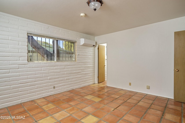 tiled spare room with an AC wall unit and brick wall