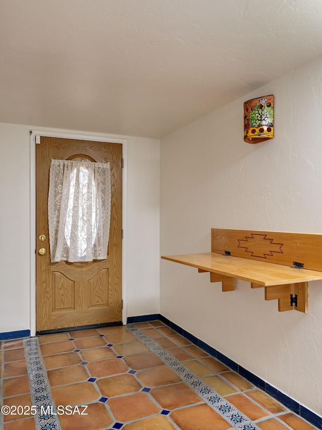 foyer with baseboards and tile patterned flooring