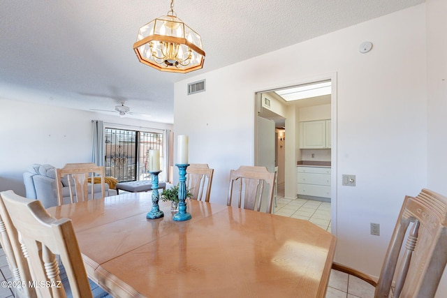 dining area with light tile patterned floors, visible vents, radiator heating unit, a textured ceiling, and ceiling fan with notable chandelier