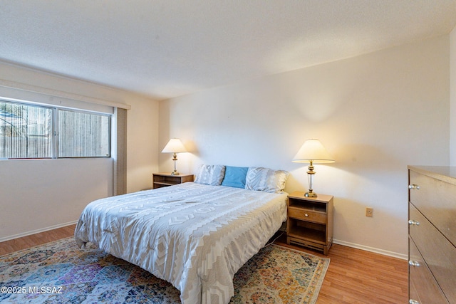 bedroom featuring light wood-style floors and baseboards