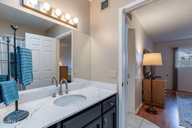 full bathroom featuring visible vents, vanity, baseboards, and wood finished floors