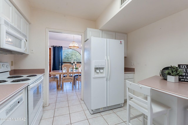 kitchen with pendant lighting, light countertops, white appliances, and white cabinets