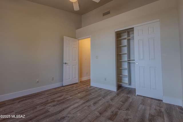 unfurnished bedroom featuring a closet, dark wood finished floors, visible vents, and baseboards