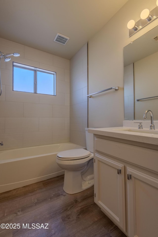 full bathroom featuring bathtub / shower combination, visible vents, toilet, vanity, and wood finished floors