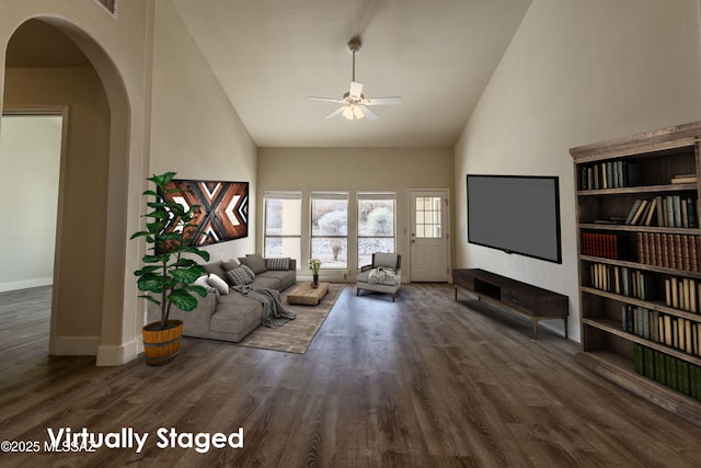 unfurnished living room with ceiling fan, high vaulted ceiling, arched walkways, and dark wood-style flooring