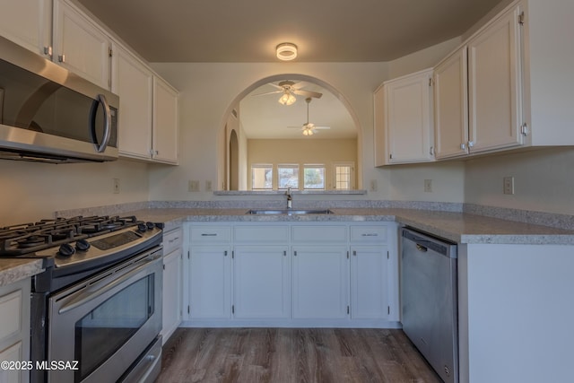 kitchen featuring stainless steel appliances, light countertops, a ceiling fan, white cabinets, and a sink