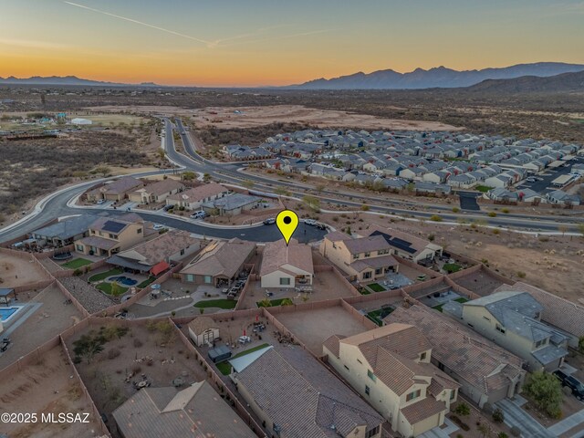 aerial view at dusk featuring a residential view and a mountain view