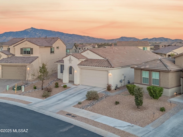 view of front of property featuring an attached garage, a tile roof, and a mountain view