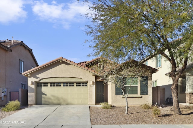 view of front of house featuring an attached garage, fence, a tile roof, concrete driveway, and stucco siding