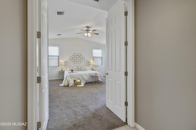 bedroom with lofted ceiling, multiple windows, visible vents, and light colored carpet