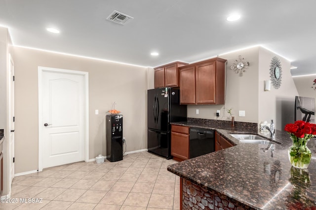 kitchen with visible vents, a sink, dark stone countertops, a peninsula, and black appliances