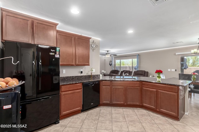 kitchen with visible vents, brown cabinets, open floor plan, a peninsula, and black appliances