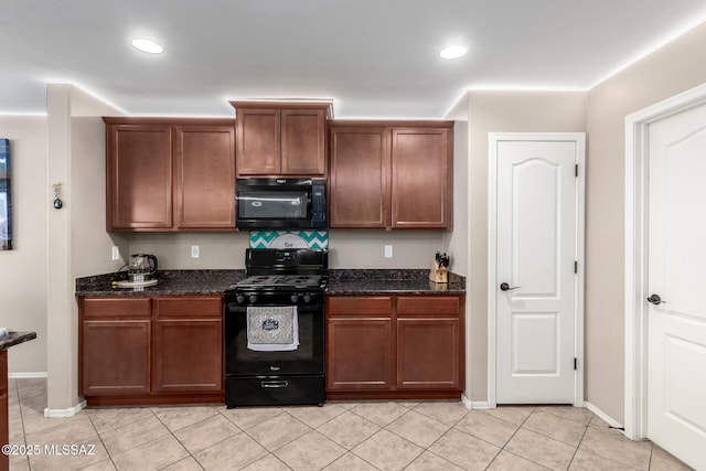 kitchen with dark stone counters, black appliances, light tile patterned floors, and recessed lighting