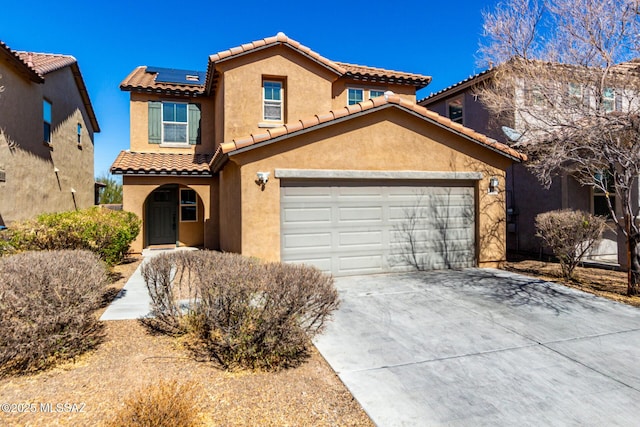 mediterranean / spanish home featuring solar panels, concrete driveway, and stucco siding