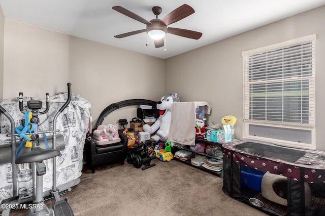 playroom with a ceiling fan and light carpet