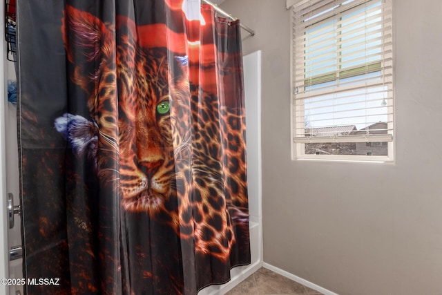 bathroom with tile patterned flooring, baseboards, and shower / bath combo with shower curtain