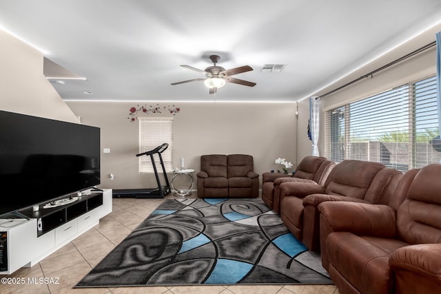 living room with light tile patterned floors, visible vents, and a ceiling fan