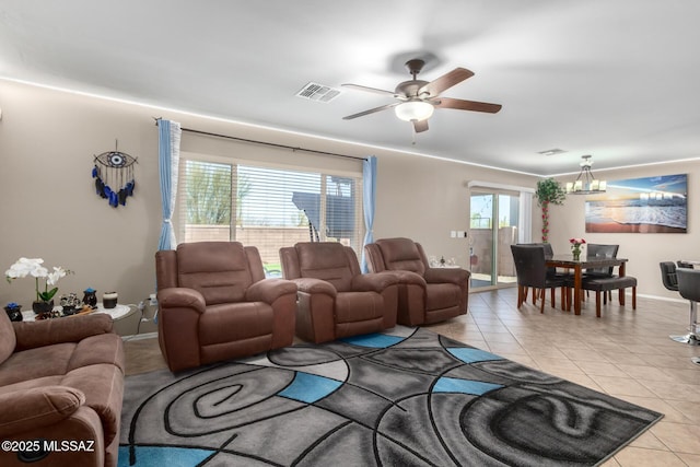 living room featuring ceiling fan with notable chandelier, visible vents, and light tile patterned floors