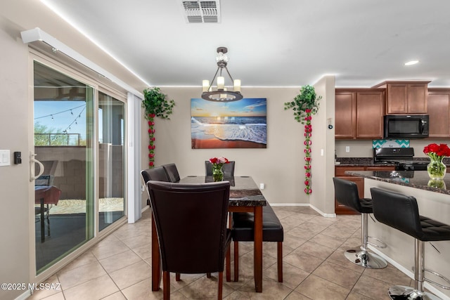 dining area with a chandelier, light tile patterned flooring, visible vents, and baseboards