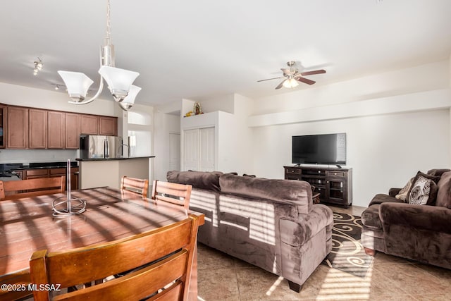 living area featuring ceiling fan with notable chandelier