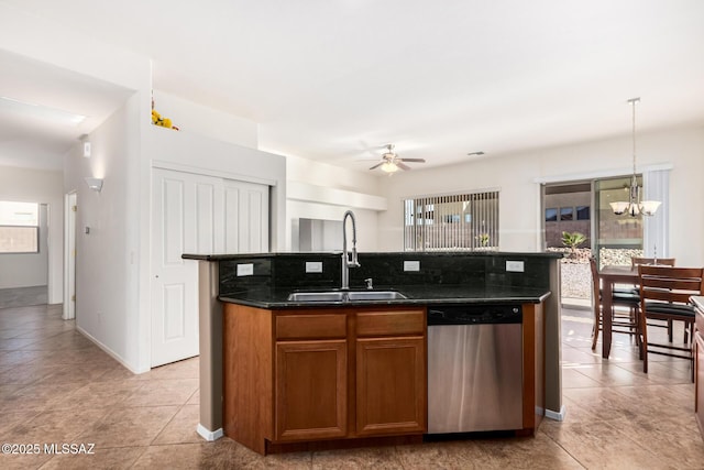 kitchen with decorative light fixtures, brown cabinetry, a kitchen island with sink, a sink, and dishwasher