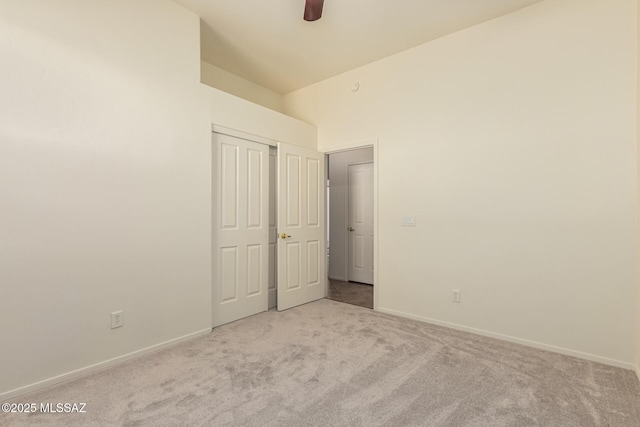 unfurnished bedroom with light carpet, baseboards, and a closet