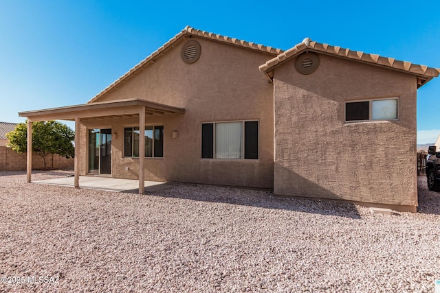 back of property featuring a tile roof, fence, a patio, and stucco siding