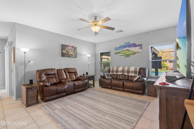 living room featuring a ceiling fan, visible vents, and light tile patterned floors