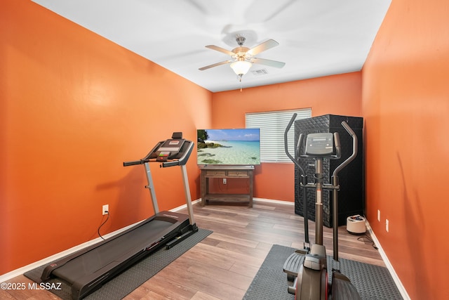 exercise area featuring light wood-style floors, visible vents, baseboards, and ceiling fan