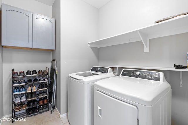 laundry room featuring light tile patterned floors, cabinet space, and washer and dryer