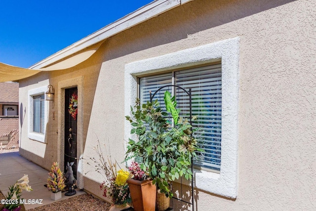 doorway to property featuring stucco siding