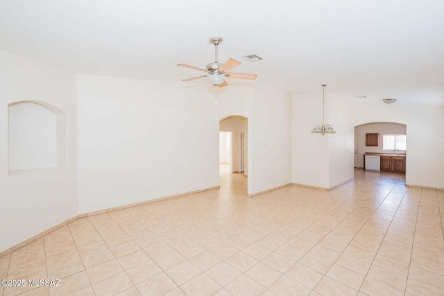 spare room with light tile patterned floors, visible vents, arched walkways, a ceiling fan, and a sink