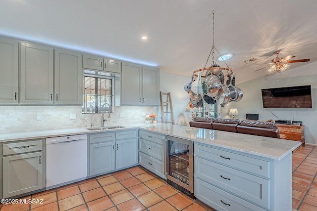 kitchen with open floor plan, wine cooler, a sink, a peninsula, and white dishwasher