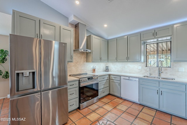 kitchen featuring light countertops, wall chimney exhaust hood, stainless steel appliances, tasteful backsplash, and a sink
