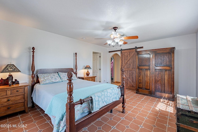 bedroom featuring tile patterned floors, arched walkways, and ceiling fan